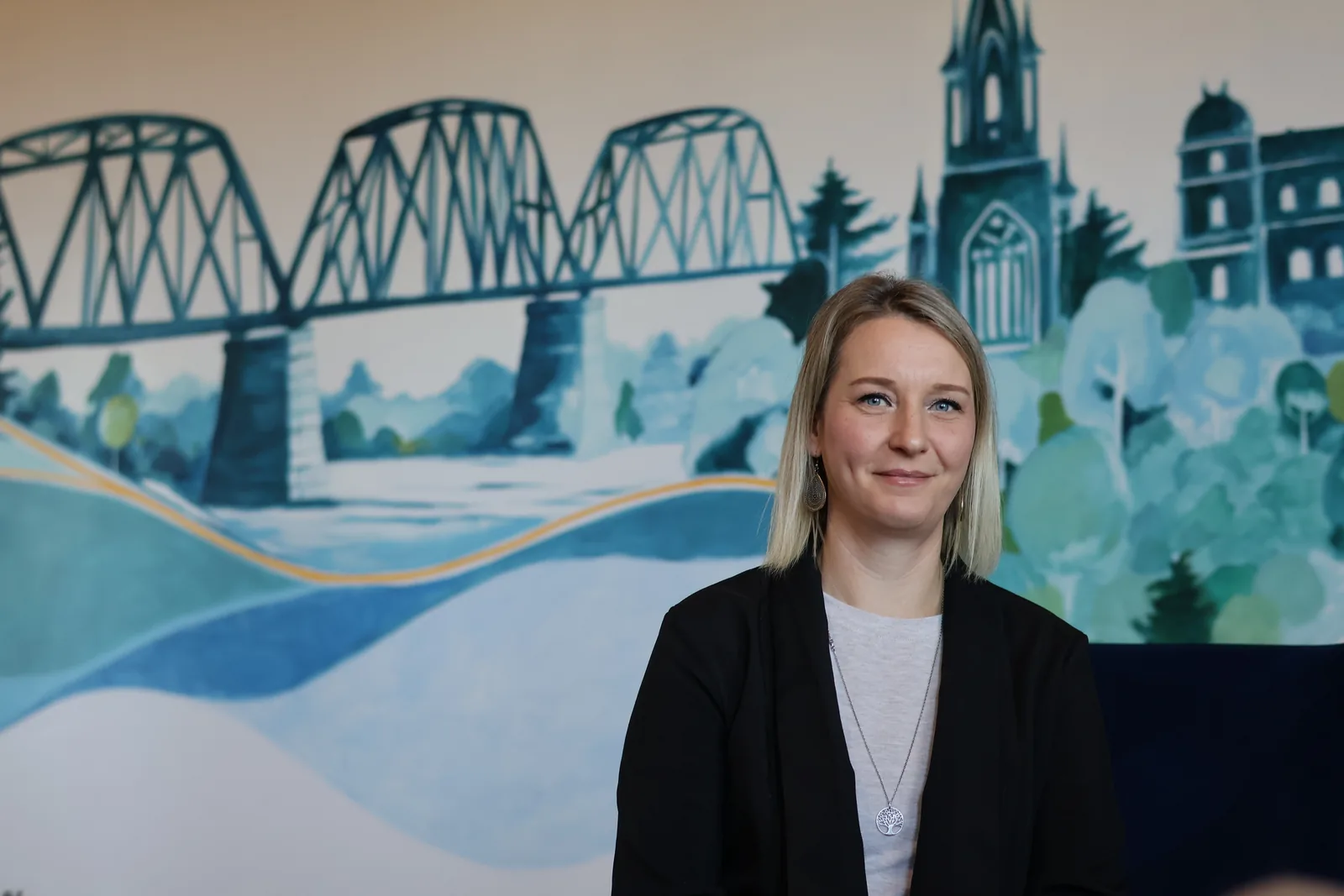 Aurore, co-founder and coach at Tidal Signal, in front of the studio mural